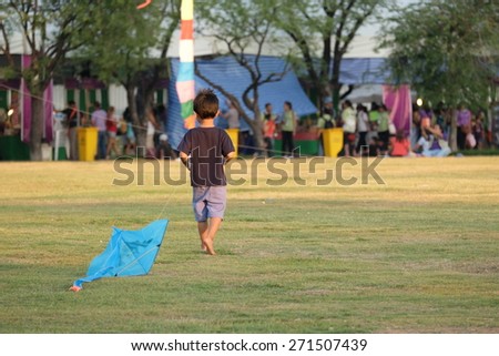 BANGKOK THAILAND - APRIL 21 A child walk with his kite between kite playing in kite festival on April 21, 2015 at Royal Plaza Bangkok Thailand.