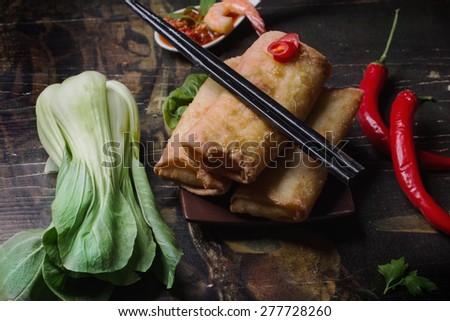 Fried spring rolls with  shrimps, bok choi, chili pepper and hot sauce on a vintage ceramic plate