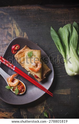 Fried spring rolls with  shrimps, bok choi, chili pepper and hot sauce on a vintage ceramic plate