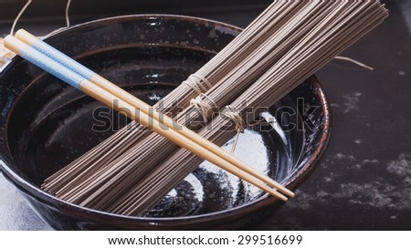 Japanese Soba noodles on a vintage wooden background with the chop sticks