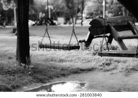 Child swing. Made from wood, hanging on chains. Photographed in a late afternoon, in a park near Palic lake, Serbia.