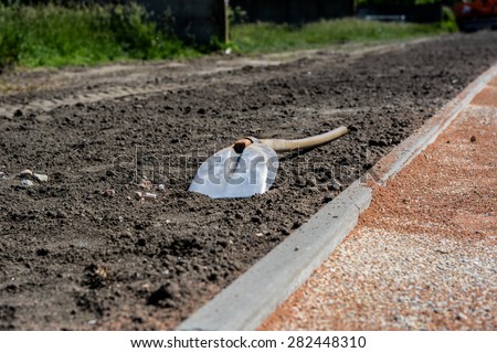 Shovel on the ground. Shovel lying on the ground. Dirt all around. Photo was taken on a nice sunny day, at construction site.