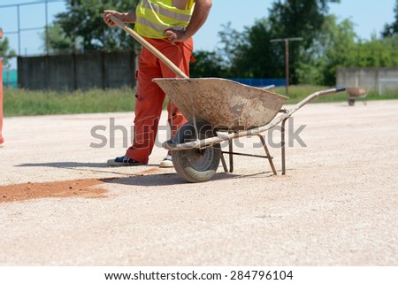 Construction worker with shovel. He is . Photo was taken on a construction site near football stadium Spartak Subotica, Serbia.