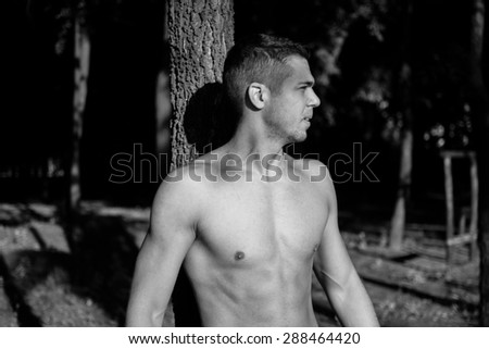 Man photographed in street workout session. Just finished one of his exercises.Photo was taken in early morning, around 6am in city park Dudova forest. Black and white photo.