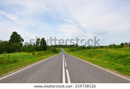 Highway in Russia in summer. The road goes downhill and turns left