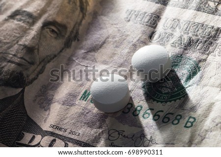 Abraham Lincoln on American dollar pill next to pills medication prescription. Cost of health care and standards of pharmaceutical business and investment economy.