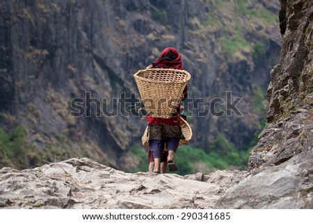 Nepali children in national clothes with baskets on mountain path