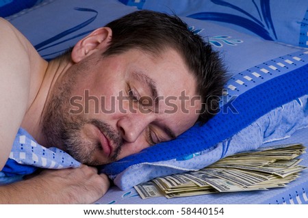 man sleeping with money under his pillow