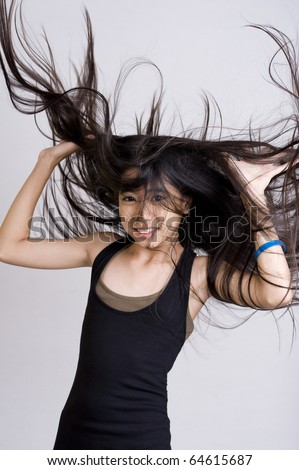 beautiful teenager with very long hair on light gray background
