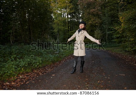 pretty asian woman standing in a forest in early fall