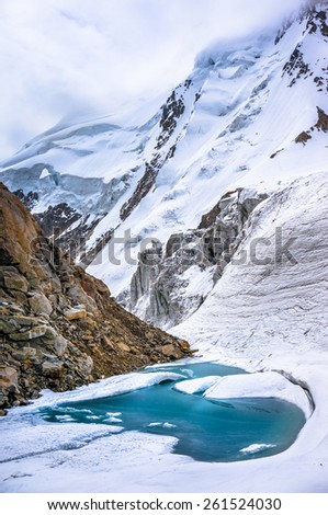 Glacial lake in the mountains of Caucasia. Too much snow and ice. Picture was taken during a trekking hike in the scenic and beautiful  Caucasus mountains, Bezengi region, Kabardino-Balkaria, Russia