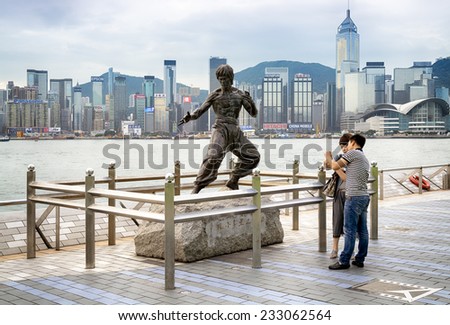 HONG KONG - NOV 09, 2014:Young Asian couple at the Bruce Lee statue in the Avenue of Stars in Hong Kong.