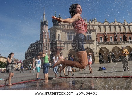 KRAKOW, POLAND - JUNE 11, 2014: Yuoth seeking escape from the summer heat in Main Square in Cracow, Poland