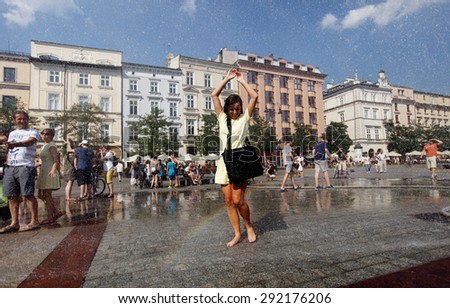 KRAKOW, POLAND - JUNE 14, 2015: Youth seeking escape from the summer heat in Main Square in Cracow, Poland