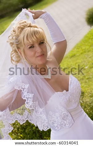 a happy bride lifts up his veil