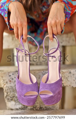 woman standing holding platform wedges shoes with open open toe