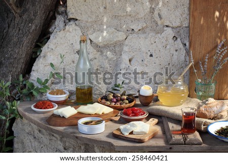 full breakfast brunch table with cheese eggs olives honey bread