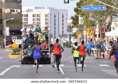 Los Angeles, CA, USA - March 15, 2015: LA Marathon. Sunset Blvd. Elite men running along the famous Sunset Strip as professional photographers photograph them from a truck.