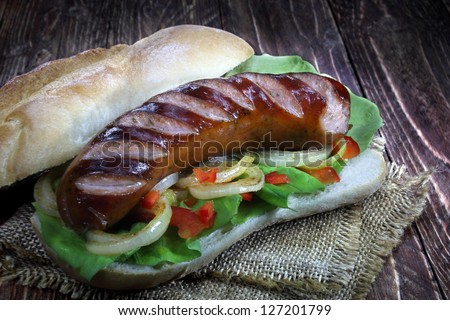 Fried sausage with bread roll, lettuce, onions and paprika