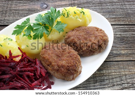 Fried minced pork cutlets with  potatoes and grated red beets