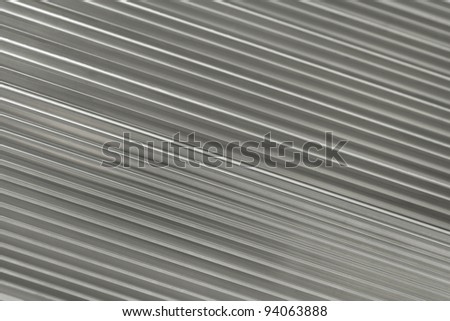 Silver metallic background containing diagonal running ridges