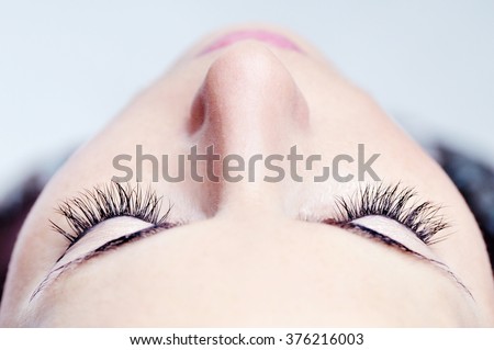 woman beautiful long eyelashes made in cosmetics salon, macro photography of pretty female eyelashes and part of face