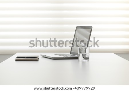 white office desk with note pad and laptop