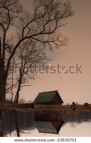 Autumn landscape. ramshackle hut in the tree by the lake