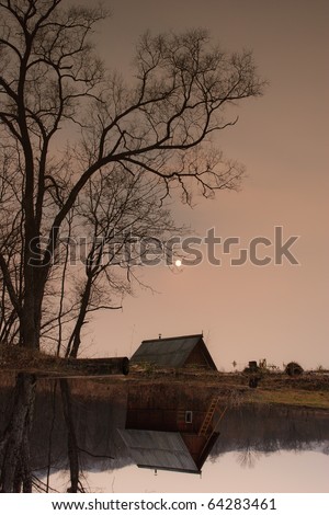 Autumn landscape. ramshackle hut in the tree by the lake
