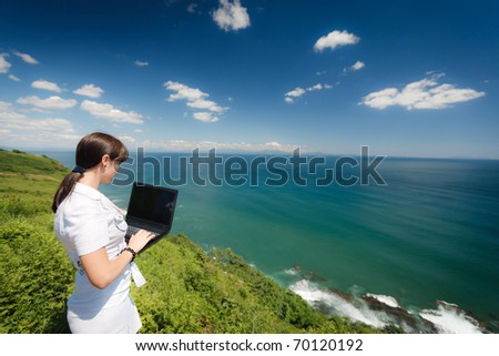 beautiful slender girl with a laptop on the nature