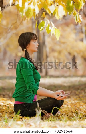 beautiful girl with dark hair, yoga in the yellow autumn leaves