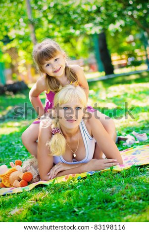 Young blonde plays with her ??little daughter in the park