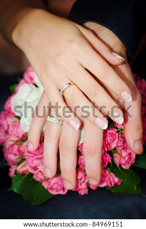 stock photo hands of men and women with wedding rings on wedding bouquet