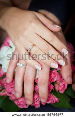 stock photo hands of men and women with wedding rings on wedding bouquet