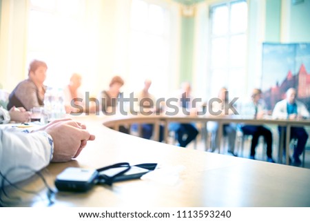 People at a round table discuss different issues. Focus on hand