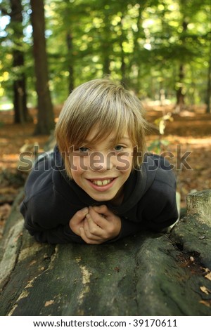 Boy posing while he's laying on a tree