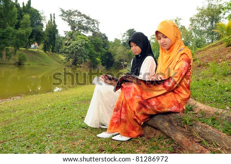 Two young Muslim girl read a magazine