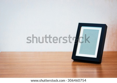 Blank black picture frame at the desk - vintage style effect picture