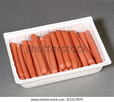 Opened package of sausages. Isolated on grey.