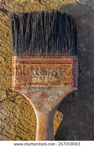Old weathered paint brush on flat stone surface