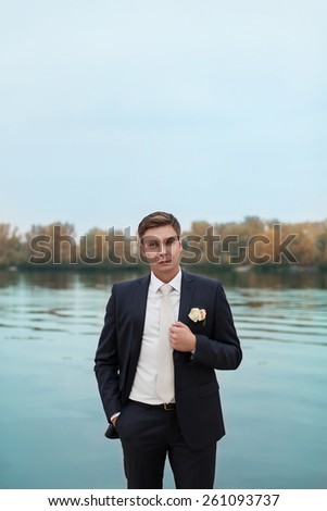 Stylish newlywed,Portrait of the groom in the park on their wedding day,the husband.
elegant bride in an expensive suit.groom waiting for the bride