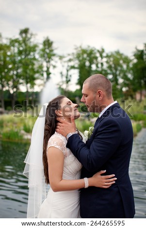 Groom gently hugs bride outdoors in the countryside.The bride and groom in the garden.\
Beautiful couple in love.