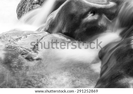 close up water fall at national park of thailand. smooth water line falling to the stream on black and white tone