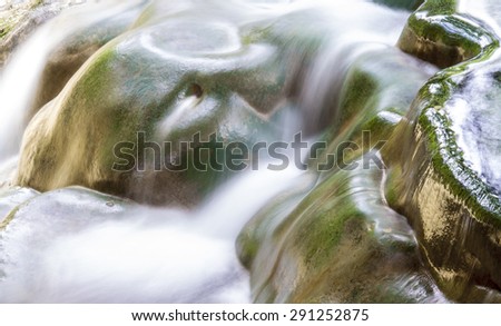 close up water fall at national park of thailand. smooth water line falling to the stream