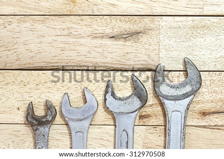 Old wrench on wood background with soft light, small to big wrench