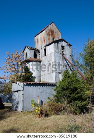 Photograph of an old abandoned granary in the midwest against a beautiful early fall blue sky.