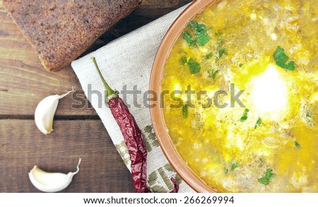National ukrainian and russian soup borsch with sour cream in ceramic bowl with black bread on wooden table. Top view