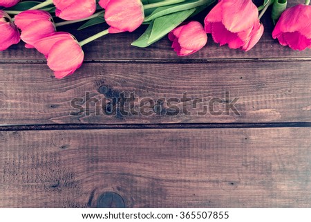 Row of tulips on wooden background with space for message.  Mother\'s Day background. Top view.