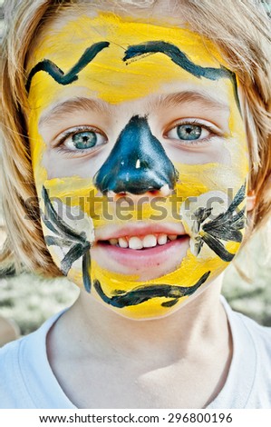 Happy smiling little boy with colorful painted face