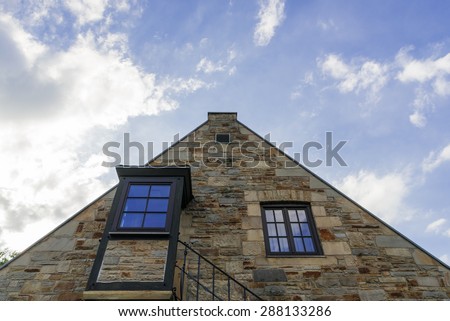 Stone facade with wooden window frames and wooden staircase